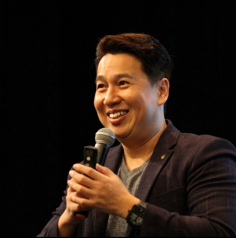 Collin Seow speaking with a microphone